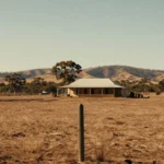 Rural acreage on the edge of town with a post and wire fence, dry paddock and distant hills